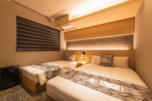 Кровать или кровати в номере GRAND BASE Kagoshima Chuo