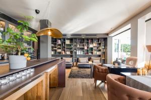 a living room with a bar with chairs and bookshelves at Boutique Hotel Valsabbion in Pula