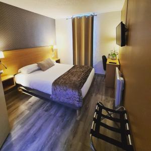 ein Hotelzimmer mit einem Bett und einem Stuhl in der Unterkunft Hotel Les Beaux Soleils in Osny