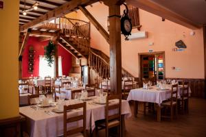 una sala da pranzo con tavoli, sedie e orologio di Mulagueta -Restauração e Turismo Rural a Vale de la Mula