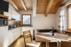 a kitchen and dining room with a table and chairs at Ciasa Funtanies Sas dla Crusc in San Martino in Badia +19 photos