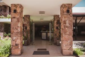 una entrada a un edificio con un pilar de piedra en Hotel Gloria en Santa Rosa de Calamuchita