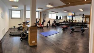 un gimnasio con equipo de ejercicios y personas de fondo en Hotel Sonne Lienz, en Lienz