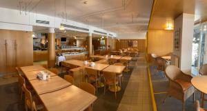a restaurant with wooden tables and chairs at Hotel Sonne Lienz in Lienz