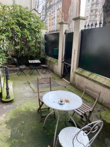 uma mesa e duas cadeiras e uma mesa e cadeiras em Cosy, charming apartment with courtyard em Paris