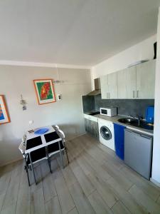 a kitchen with a table and a washing machine at casa penelope in Costa Del Silencio