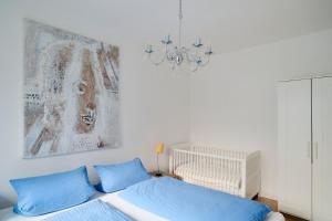 リューベックにあるFerienwohnung Strand Bucht Moba-Travelのベッドルーム1室(青い枕と絵画付)