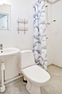 a white bathroom with a toilet and a sink at Bed's Motell & Rumsuthyrning in Norrköping