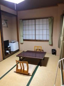 a living room with a ping pong table and two chairs at Shiunso in Nikko