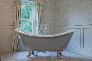a bath tub in a bathroom with a window at Ballyseede Castle in Tralee