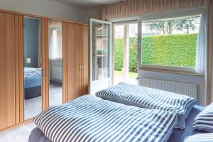 1 dormitorio con 2 camas frente a una ventana en Ferienhaus Martens en Schortens