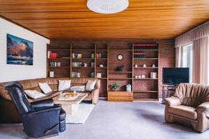 sala de estar con sofá, sillas y TV en Ferienhaus Martens en Schortens
