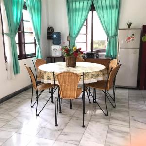 a kitchen with a table with chairs and a refrigerator at Villa Green Fresh - Bumi Ciherang - Cipanas in Tjiandjur
