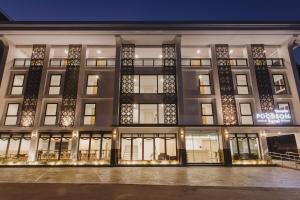 a large building with illuminated windows at night at Poodson Hotel Chiangmai in Chiang Mai