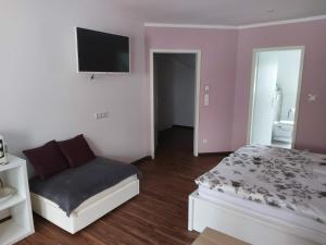 1 dormitorio con 1 cama y TV de pantalla plana en Ferienwohnung Grunwald, en Oberhof