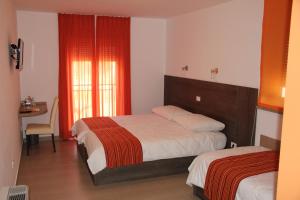 1 Schlafzimmer mit 2 Betten und einem Tisch mit einem Schreibtisch in der Unterkunft Guesthouse Ošterija in Branik