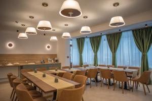 une salle de conférence avec des tables, des chaises et des fenêtres dans l'établissement Boga Rooms, à Sinaia