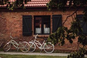 two bikes are parked against a brick building at Osada pod Lipą in Ostrowice