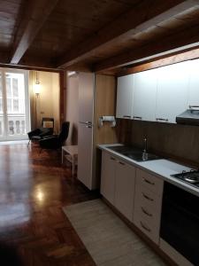 cocina con armarios blancos y encimera en Il Castello Apartment en Nápoles