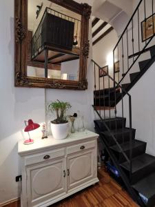 een kamer met een dressoir met een spiegel en een trap bij Luxury Loft 89 in Milaan