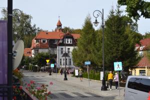 una calle con edificios y gente caminando por la calle en Apartament Roland, en Świeradów-Zdrój