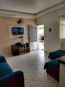 ein Wohnzimmer mit Sofa und Fernseher in der Unterkunft Casa grande e confortável em Ilha Comprida in Ilha Comprida