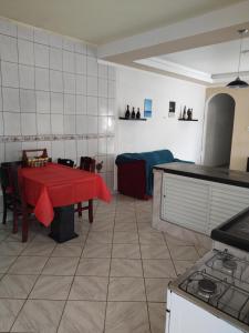 eine Küche mit einem Tisch und einem roten Tischtuch in der Unterkunft Casa grande e confortável em Ilha Comprida in Ilha Comprida + 11 Fotos