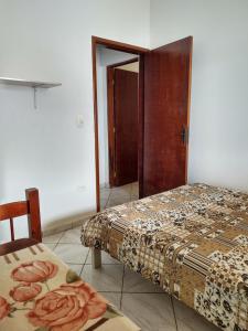 Zimmer mit 2 Betten und einer Tür zu einem Schlafzimmer in der Unterkunft Casa grande e confortável em Ilha Comprida in Ilha Comprida