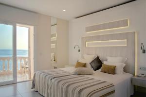 ein weißes Schlafzimmer mit einem großen Bett und einem Balkon in der Unterkunft Vistabella in Roses