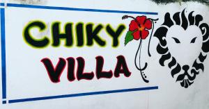 ワタムにあるChiky Villaの鶏と花の看板