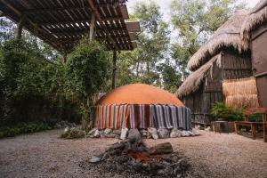 an orange dome with a blanket over a fire in a yard at Tunich Jungle Cabañas in Tulum
