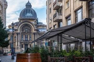 een gebouw met een klokkentoren in een stadsstraat bij History Museum Apartment in Boekarest