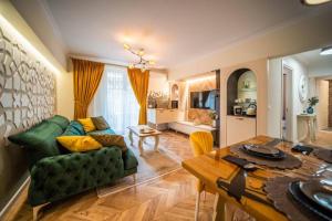 een woonkamer met een groene bank en een tafel bij History Museum Apartment in Boekarest