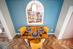 een eetkamer met een tafel en gele stoelen bij History Museum Apartment in Boekarest