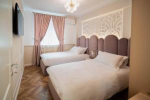 een hotelkamer met twee bedden en een raam bij History Museum Apartment in Boekarest