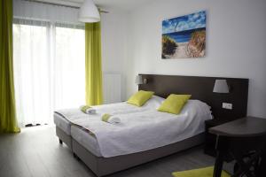 a bedroom with a large bed with yellow pillows at Pokoje Gościnne "MARIA" in Białogóra +14 photos
