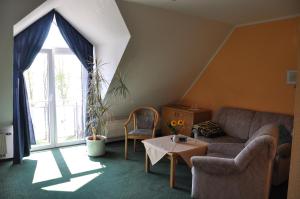 
a living room filled with furniture and a window at Pension Müritzblick in Waren
