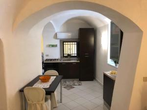 a kitchen with an archway and a table and chairs at Casa Vacanze Gaia in Biancavilla