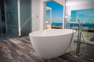 uma banheira branca na casa de banho com vista para o oceano em Vistabella em Roses