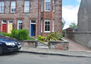 a car parked in front of a brick house at Links Corner in Gullane