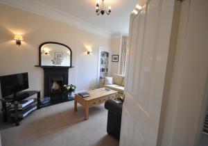 a living room with a fireplace and a television at Links Corner in Gullane