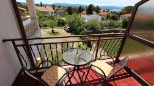 a balcony with a table and chairs on a patio at Room Jelka 3 in Malinska