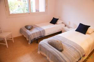 ein Schlafzimmer mit zwei Betten, einem Stuhl und einem Fenster in der Unterkunft Apartment - Sleeps 4 - Pool - Terrace - Parking in Torre-Pacheco