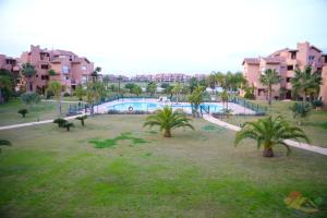 ein Park mit Swimmingpool und Palmen in der Unterkunft Apartment - Sleeps 4 - Pool - Terrace - Parking in Torre-Pacheco