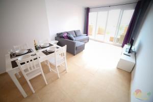 ein Wohnzimmer mit Tisch und Stühlen und einer Couch in der Unterkunft Apartment - Sleeps 4 - Pool - Terrace - Parking in Torre-Pacheco