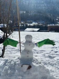 a snowman is standing in the snow at Family Hotel Kala in Mestia