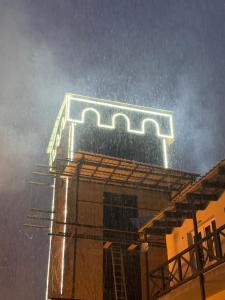 a building with a neon sign on top of it at Family Hotel Kala in Mestia