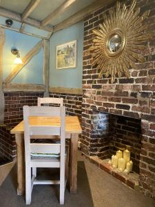 a table and a chair in a room with a brick wall at The Crown Inn Dial Post in Horsham