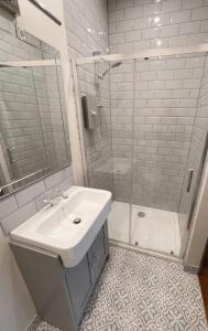 uma casa de banho branca com um lavatório e um chuveiro em The Crown Inn Dial Post em Horsham