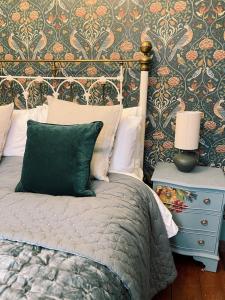a bedroom with a bed and a night stand with a lamp at The Crown Inn Dial Post in Horsham